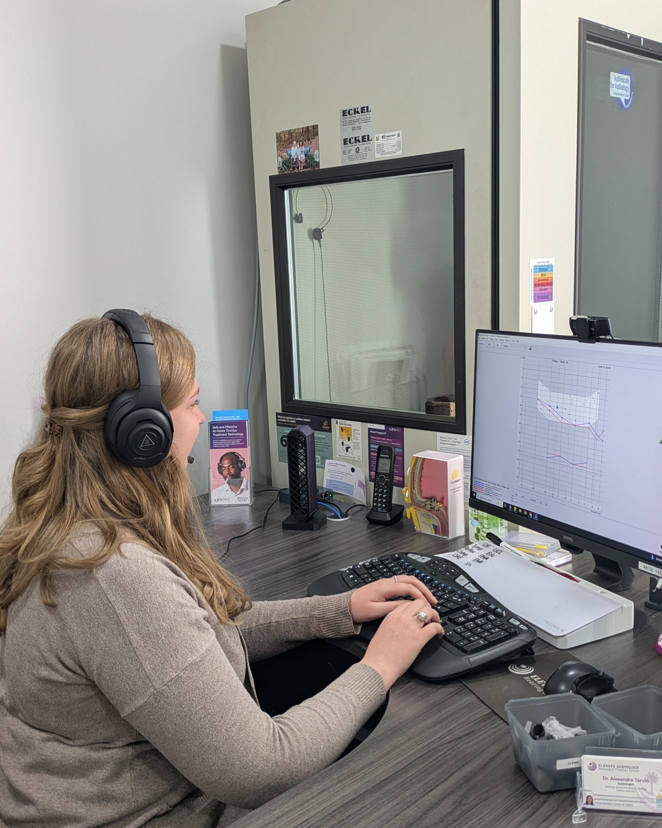 Audiologist performing comprehensive diagnostic testing in a calibrated sound booth